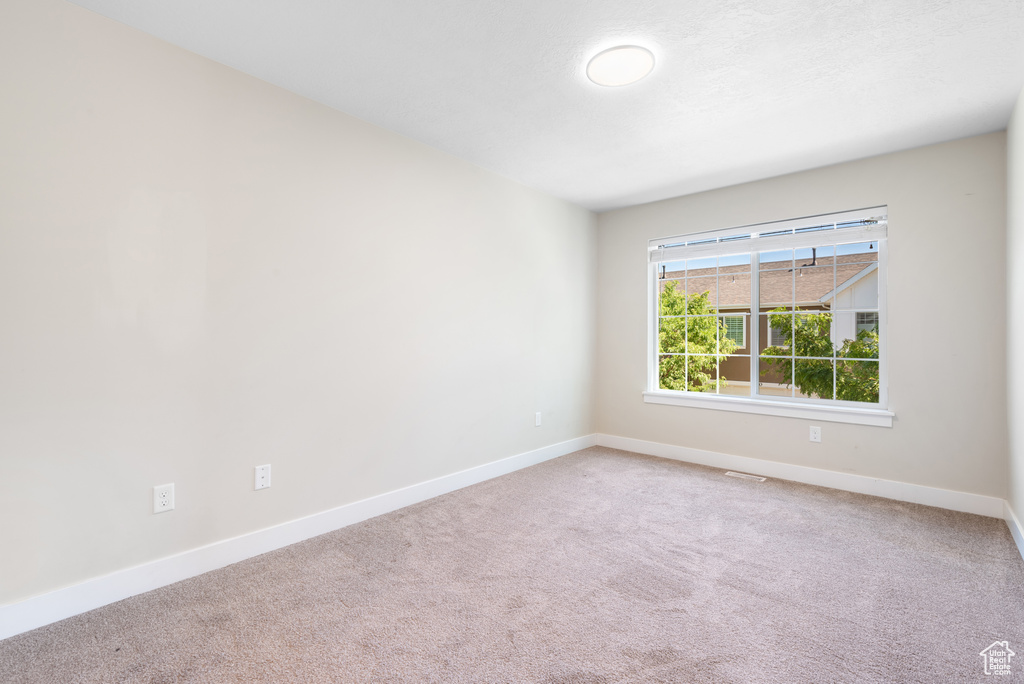 Carpeted empty room with baseboards