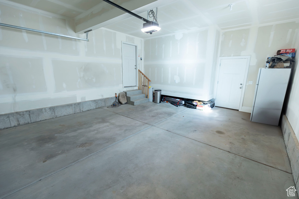 Garage with a garage door opener and freestanding refrigerator