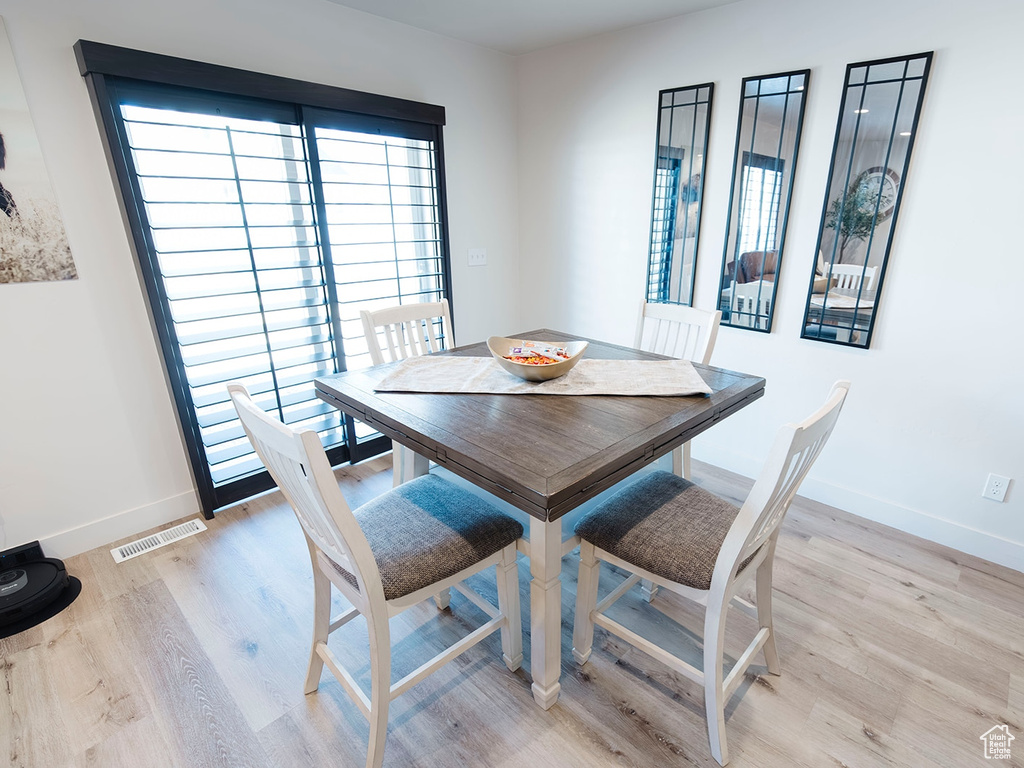 Dining area with light wood-style flooring and baseboards