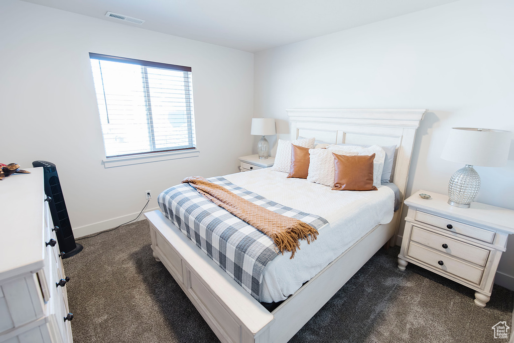 Bedroom featuring dark carpet and baseboards