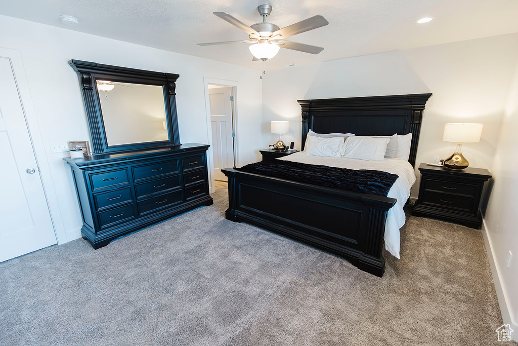 Carpeted bedroom featuring a ceiling fan