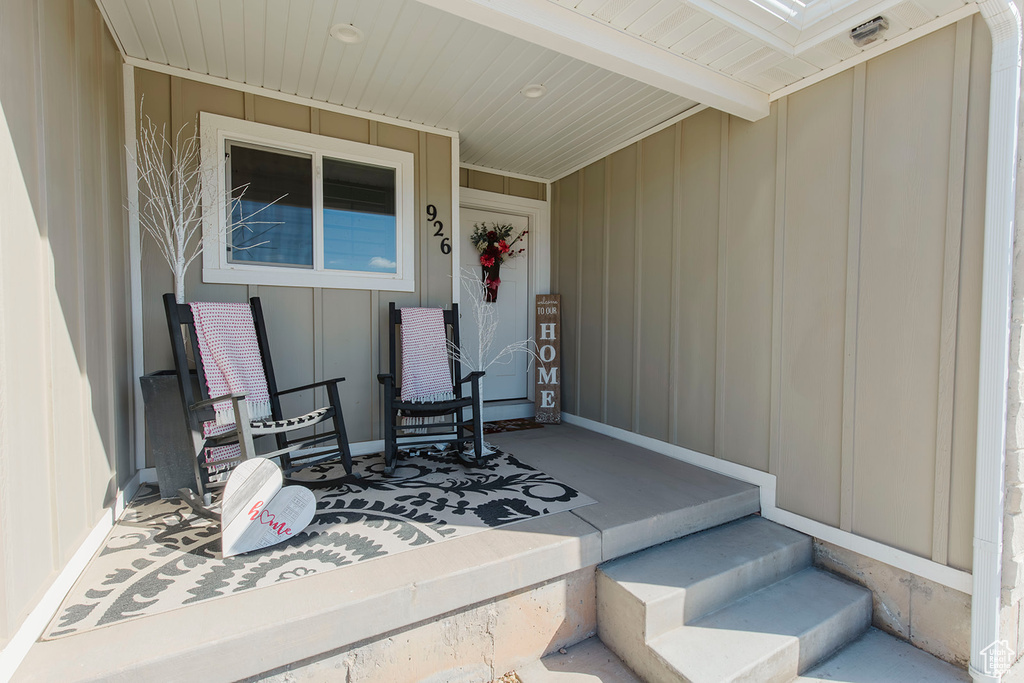 Property entrance featuring covered porch and board and batten siding