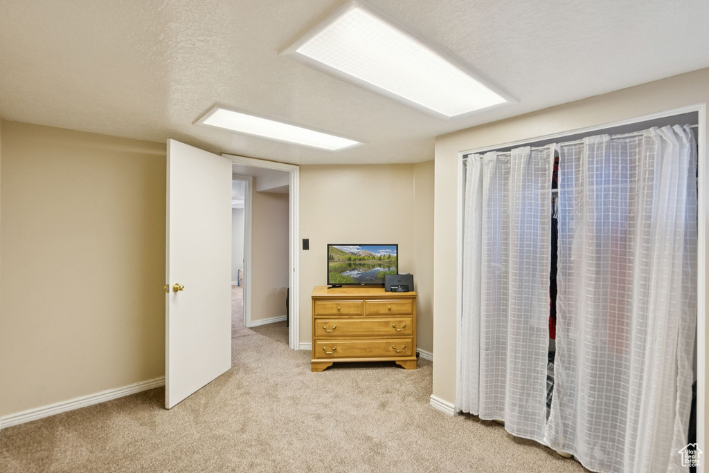 Bedroom with light colored carpet and baseboards