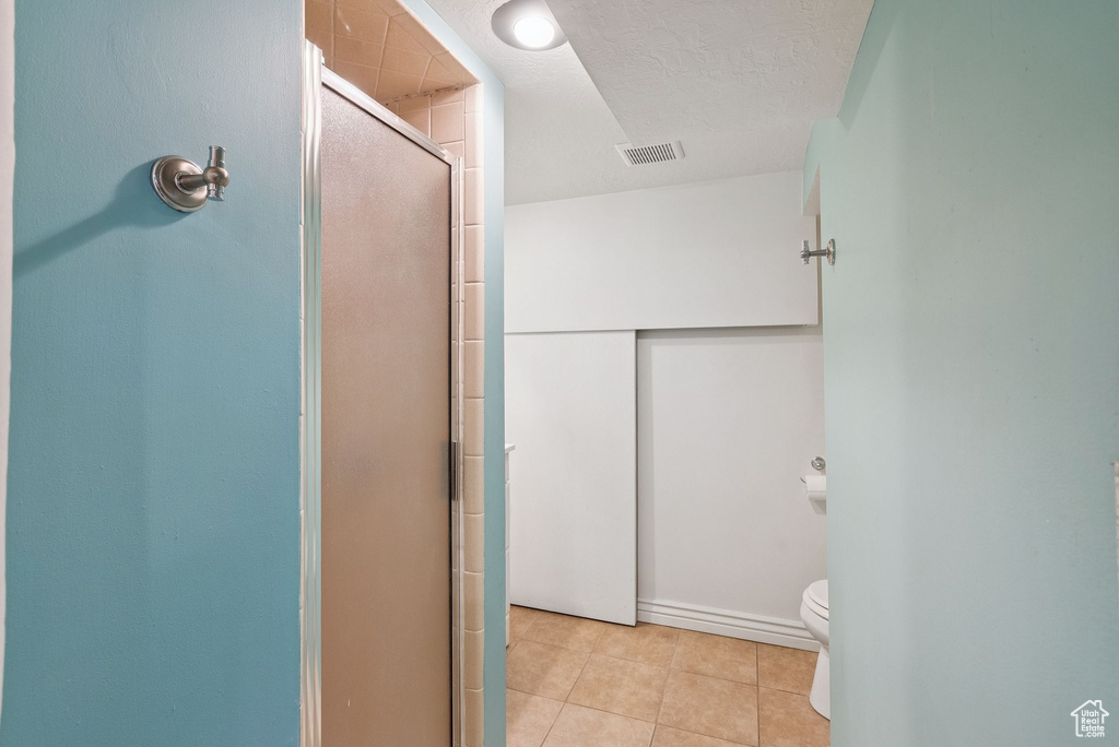 Full bath with a stall shower and tile patterned flooring