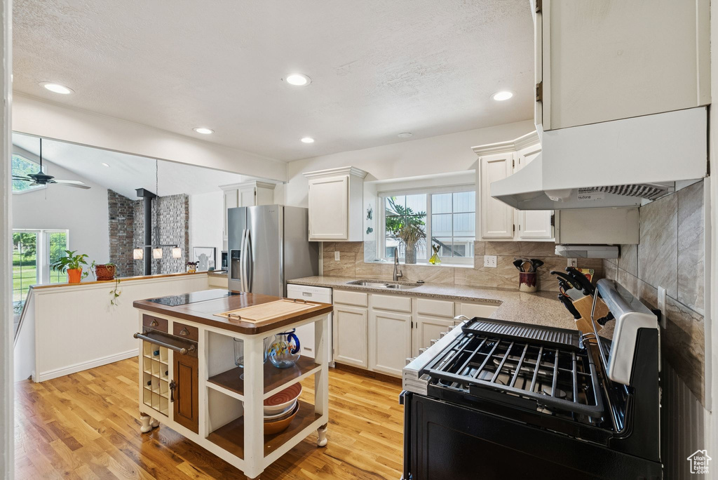 Kitchen featuring stainless steel appliances, plenty of natural light, white cabinetry, a ceiling fan, and recessed lighting
