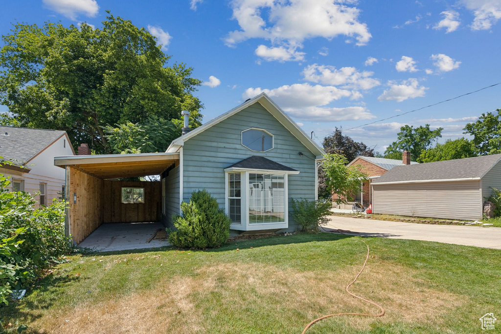 View of front of home featuring a front lawn, driveway, and a carport