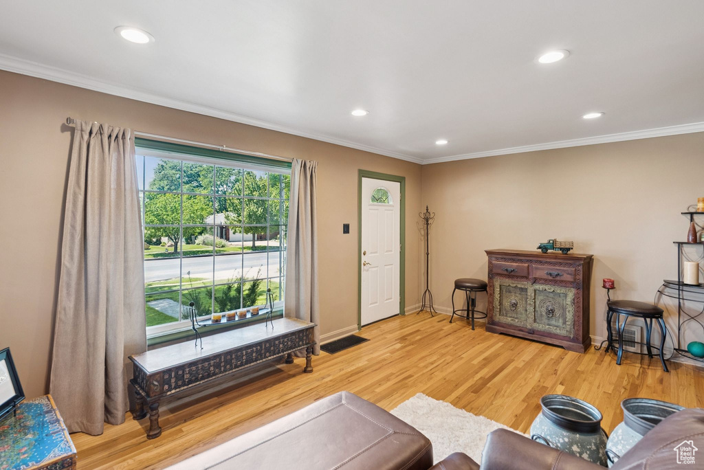 Living room with crown molding, recessed lighting, and wood finished floors