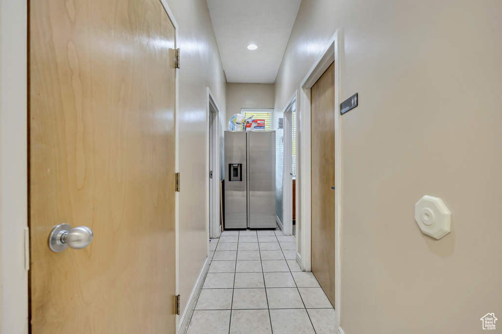 Hallway with light tile patterned floors and baseboards