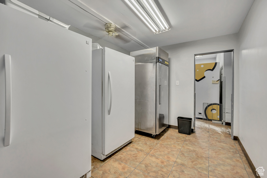 Below grade area featuring freestanding refrigerator