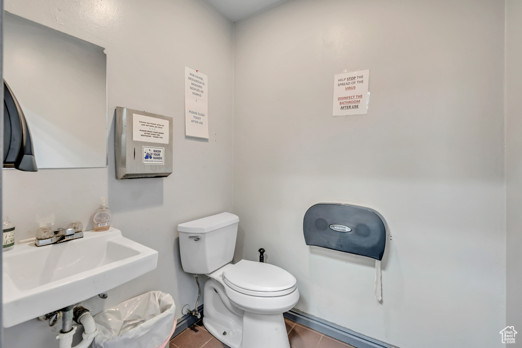 Half bathroom with toilet and tile patterned floors