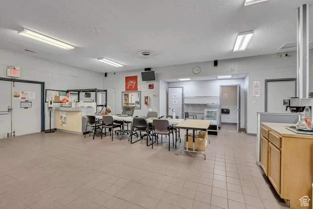 Dining space featuring a textured ceiling and light tile patterned flooring