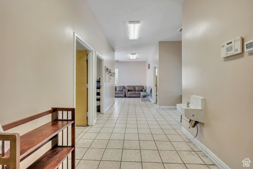 Corridor with light tile patterned floors and baseboards