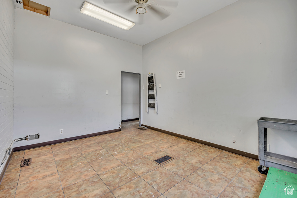 Empty room featuring a ceiling fan and baseboards