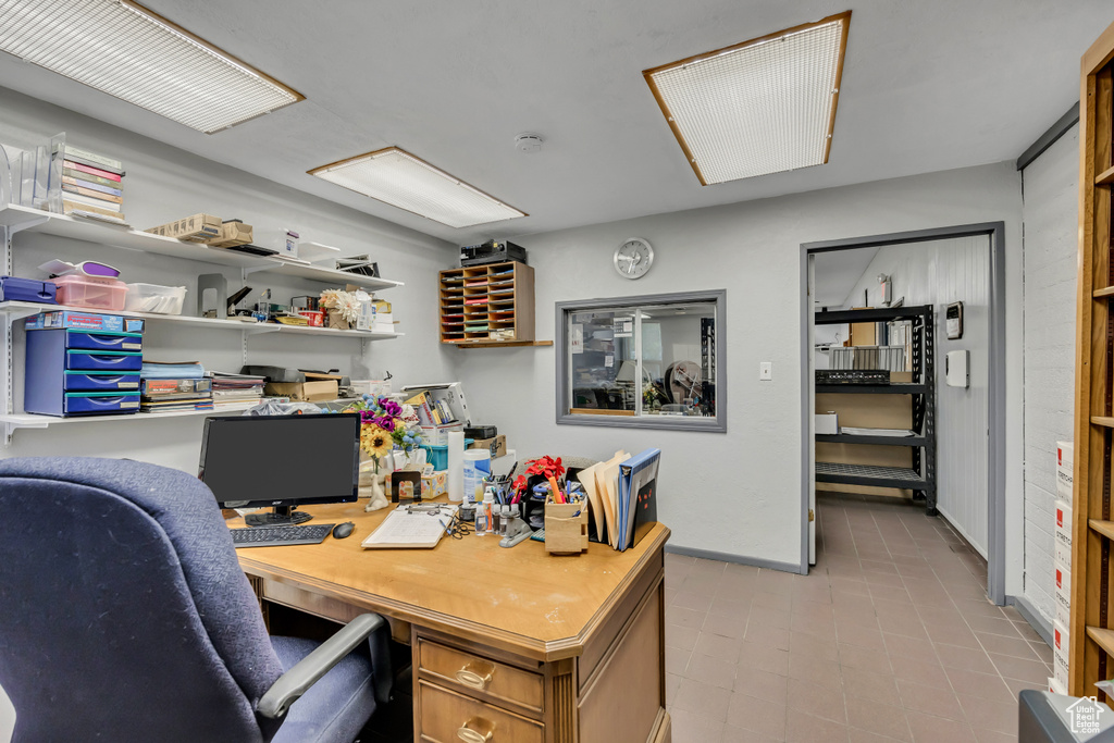Home office featuring built in desk and light tile patterned flooring