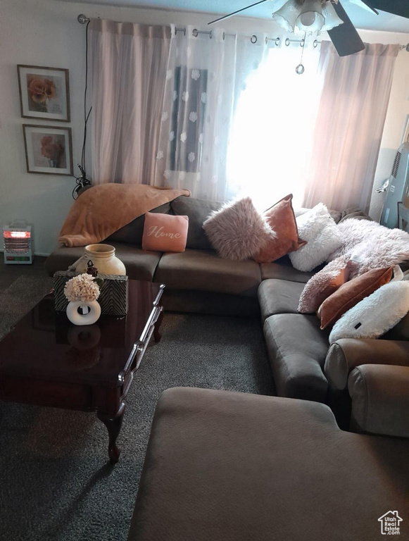 Carpeted living room featuring ceiling fan