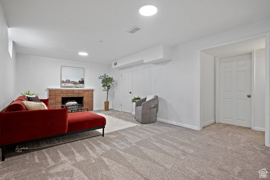 Carpeted living room with a brick fireplace and recessed lighting