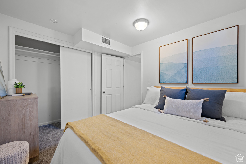 Carpeted bedroom featuring a closet and baseboards