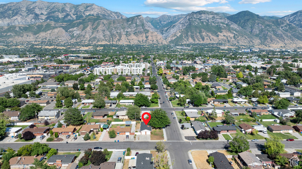 Aerial view of property and surrounding area featuring a mountain backdrop