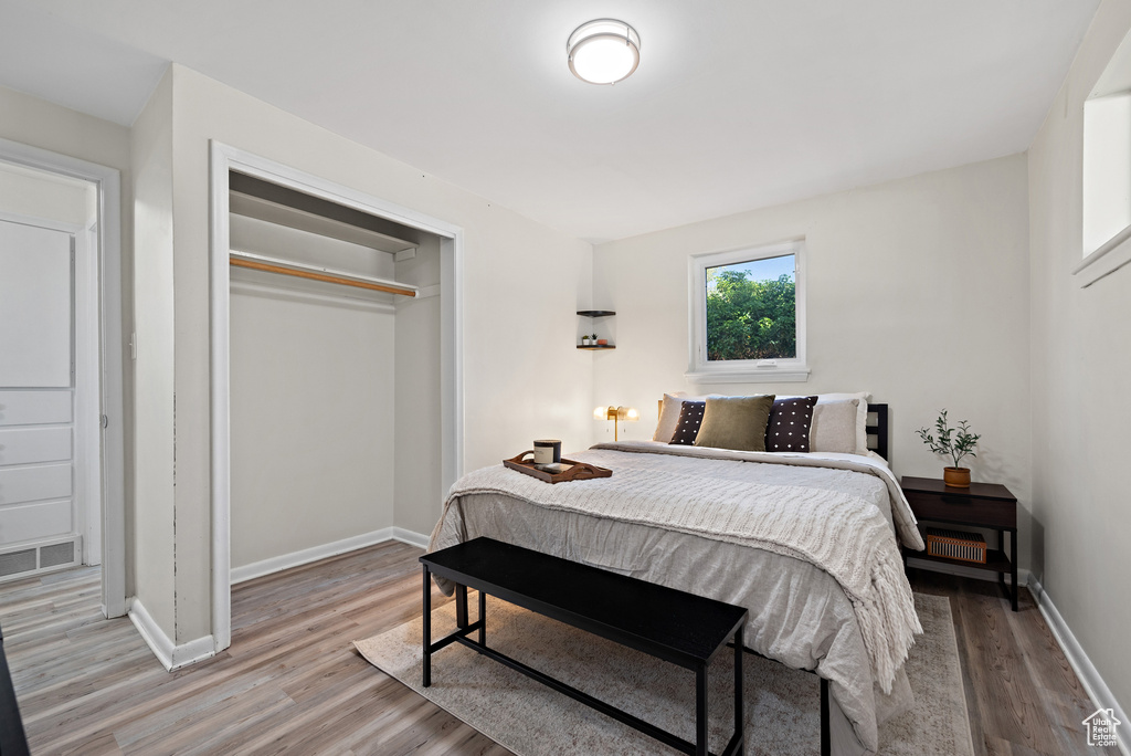 Bedroom with light wood-type flooring and a closet