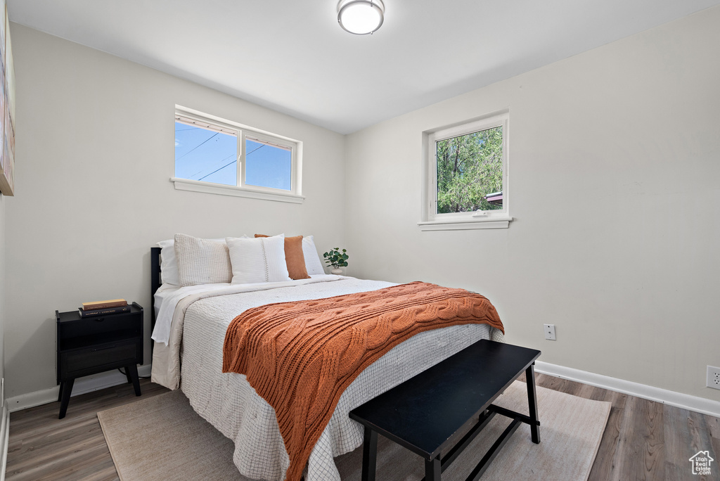Bedroom with multiple windows and wood finished floors