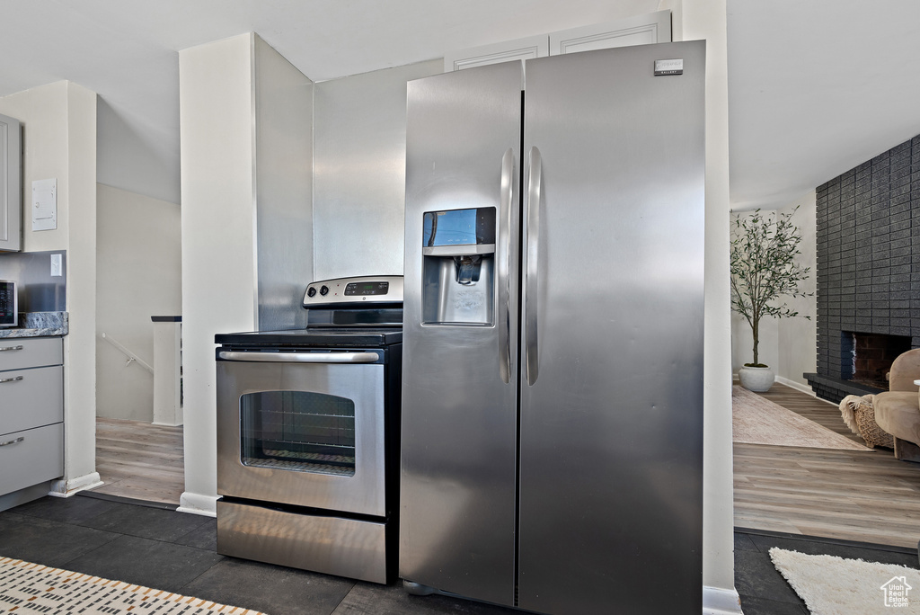 Kitchen featuring appliances with stainless steel finishes and a brick fireplace