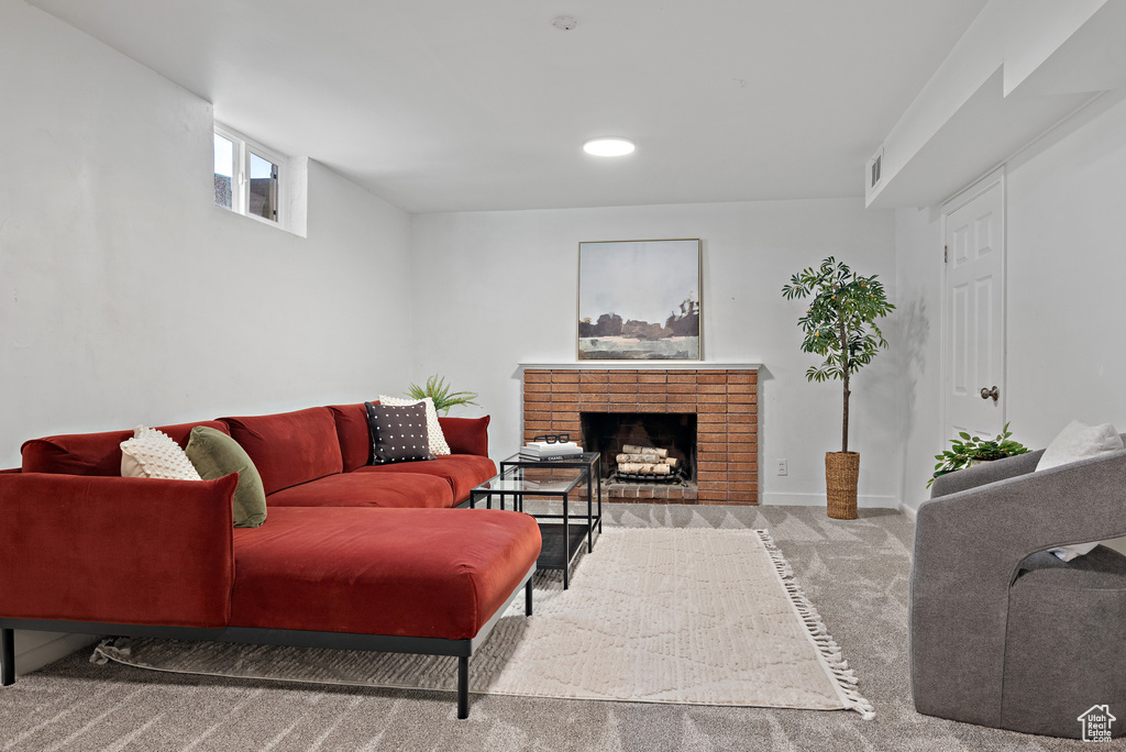 Carpeted living area featuring a brick fireplace and recessed lighting