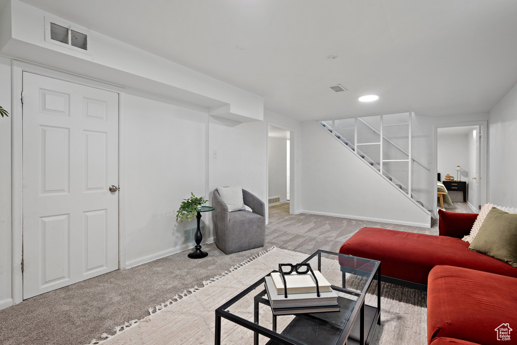 Carpeted living room featuring stairway and recessed lighting