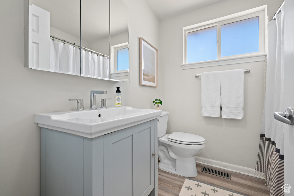 Full bath with vanity and wood finished floors