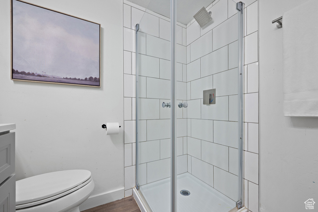 Full bath featuring a shower stall, vanity, and wood finished floors