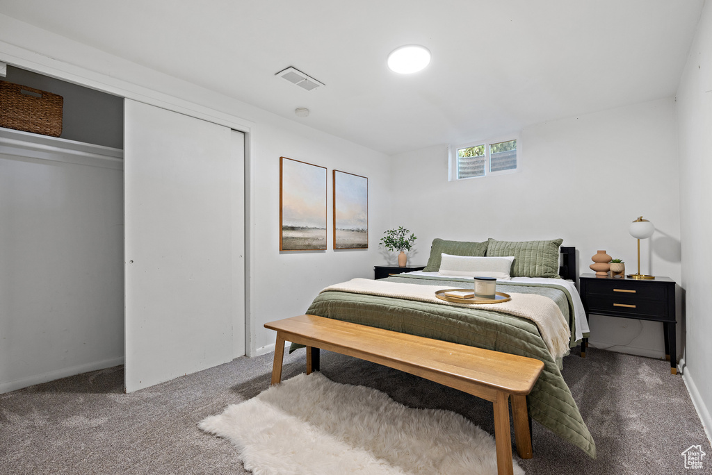 Carpeted bedroom featuring a closet and baseboards