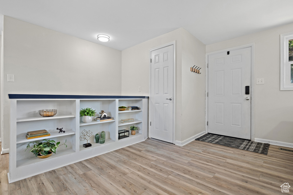 Foyer with light wood-style flooring and baseboards