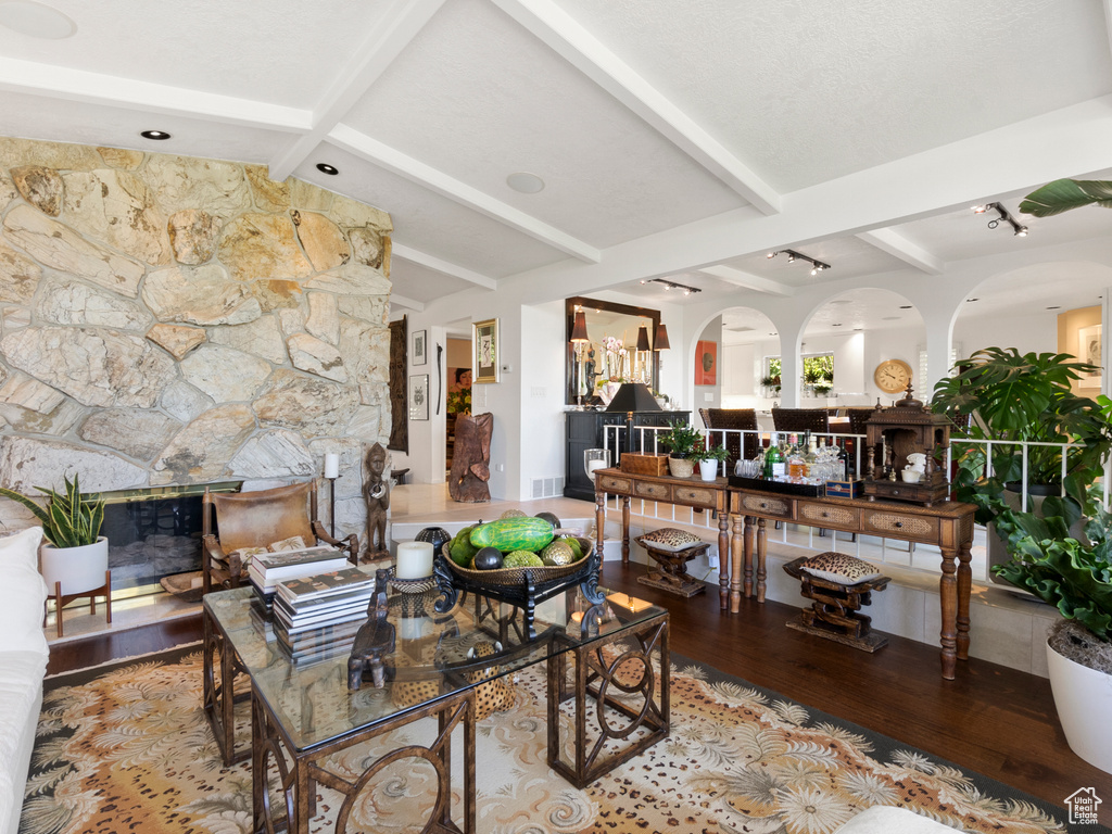 Living area with wood finished floors, a fireplace, and arched walkways