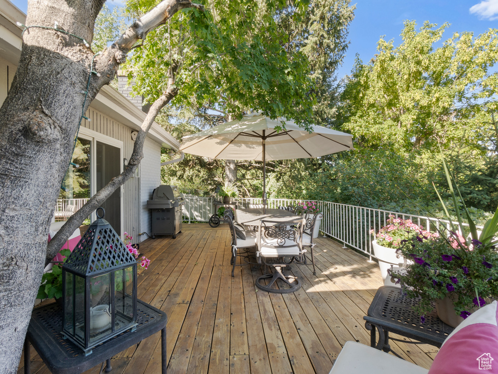 Wooden deck featuring a grill and outdoor dining space