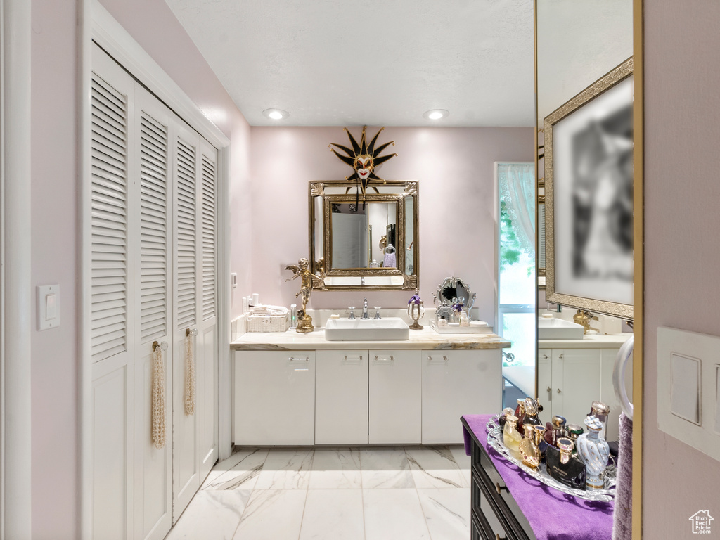 Full bath with a closet, vanity, recessed lighting, and marble finish flooring
