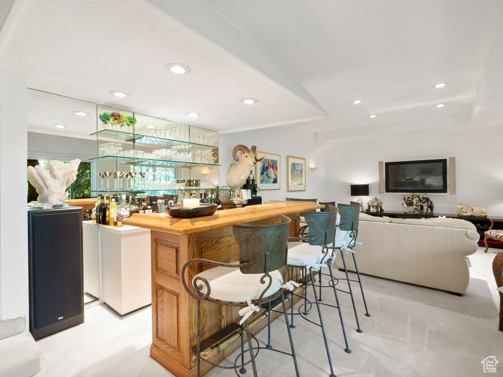 Indoor wet bar with recessed lighting, light carpet, and a raised ceiling
