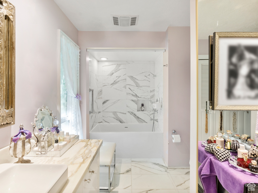 Full bathroom with marble finish floors, vanity, and  shower combination