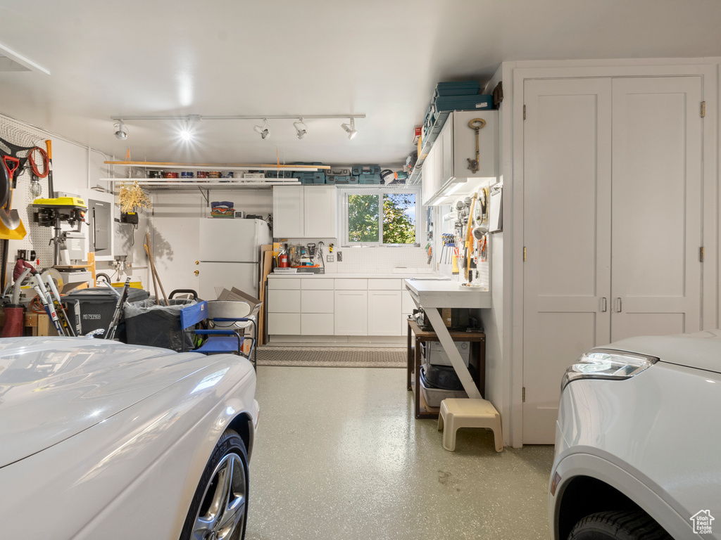 Garage with freestanding refrigerator and electric panel