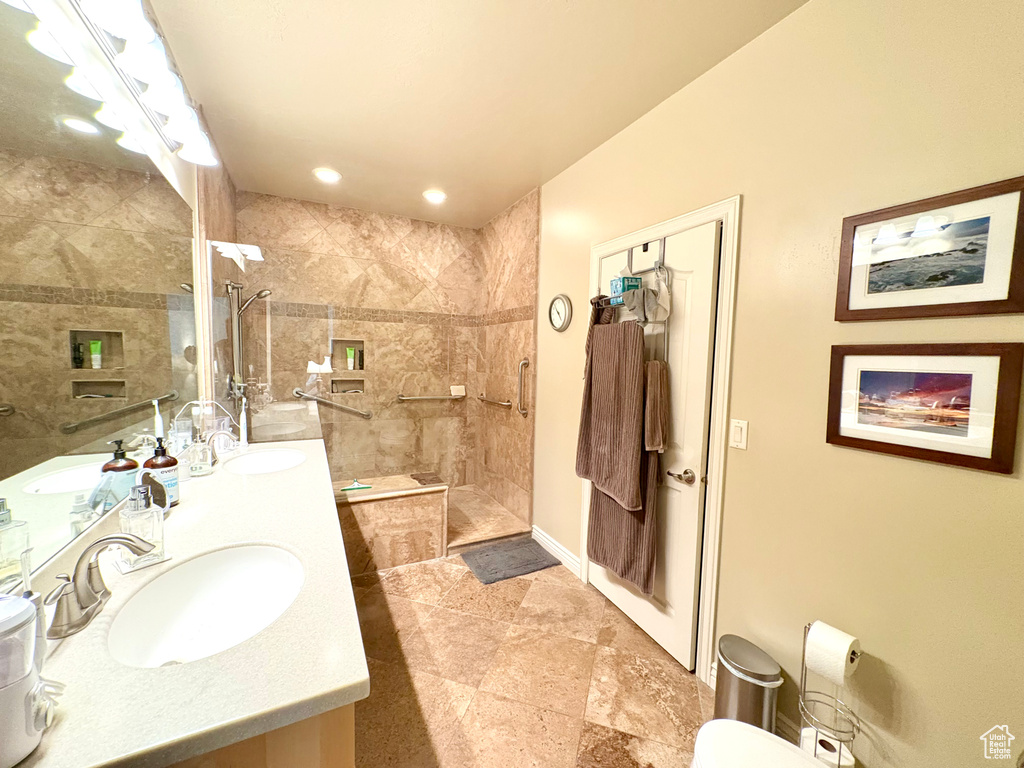 Full bathroom with double vanity, a walk in shower, and recessed lighting