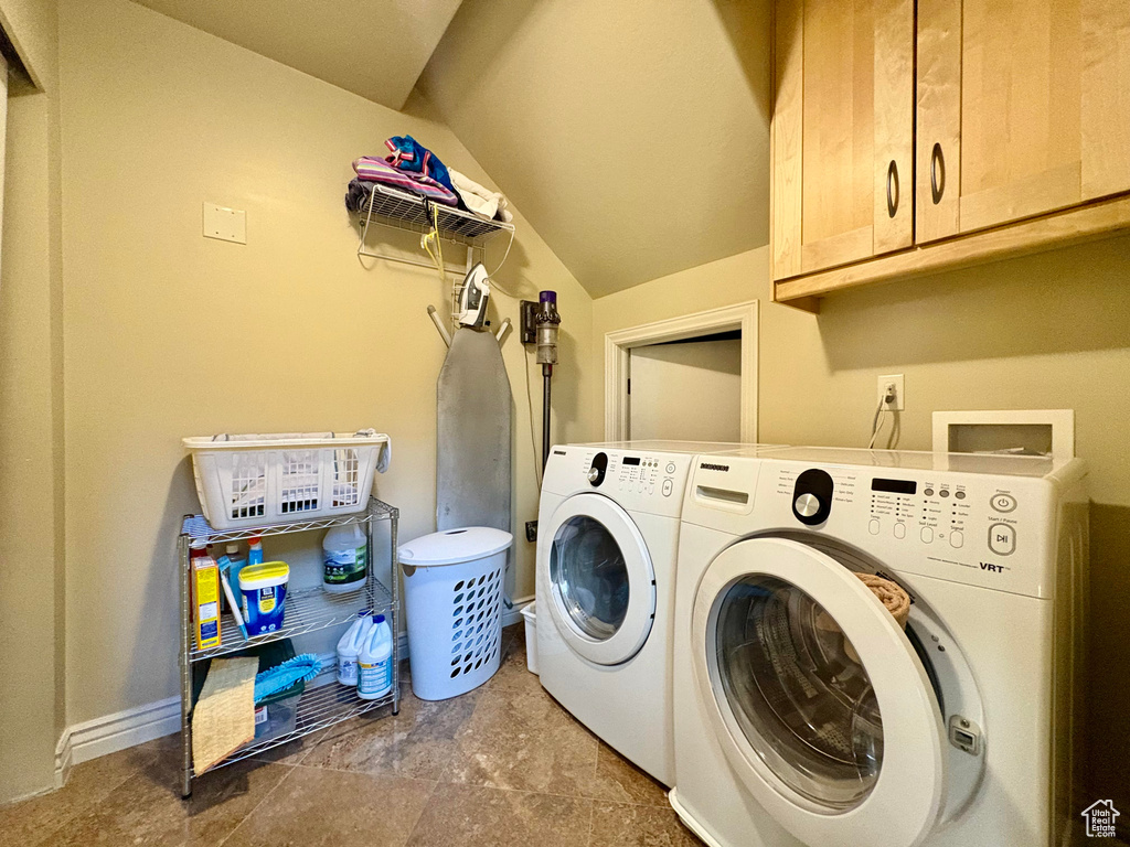 Laundry area featuring separate washer and dryer and cabinet space
