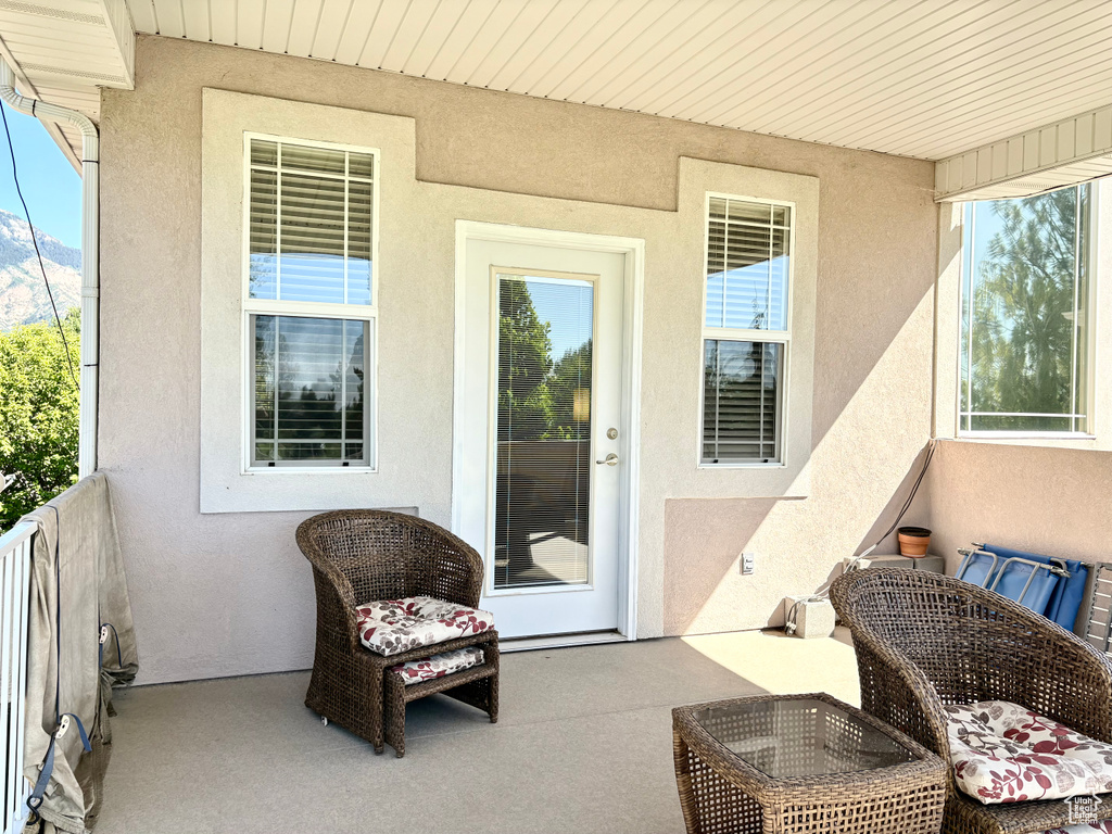 Property entrance featuring stucco siding and a balcony