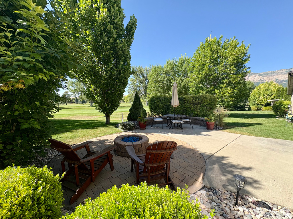 View of patio / terrace featuring an outdoor fire pit and a mountain view