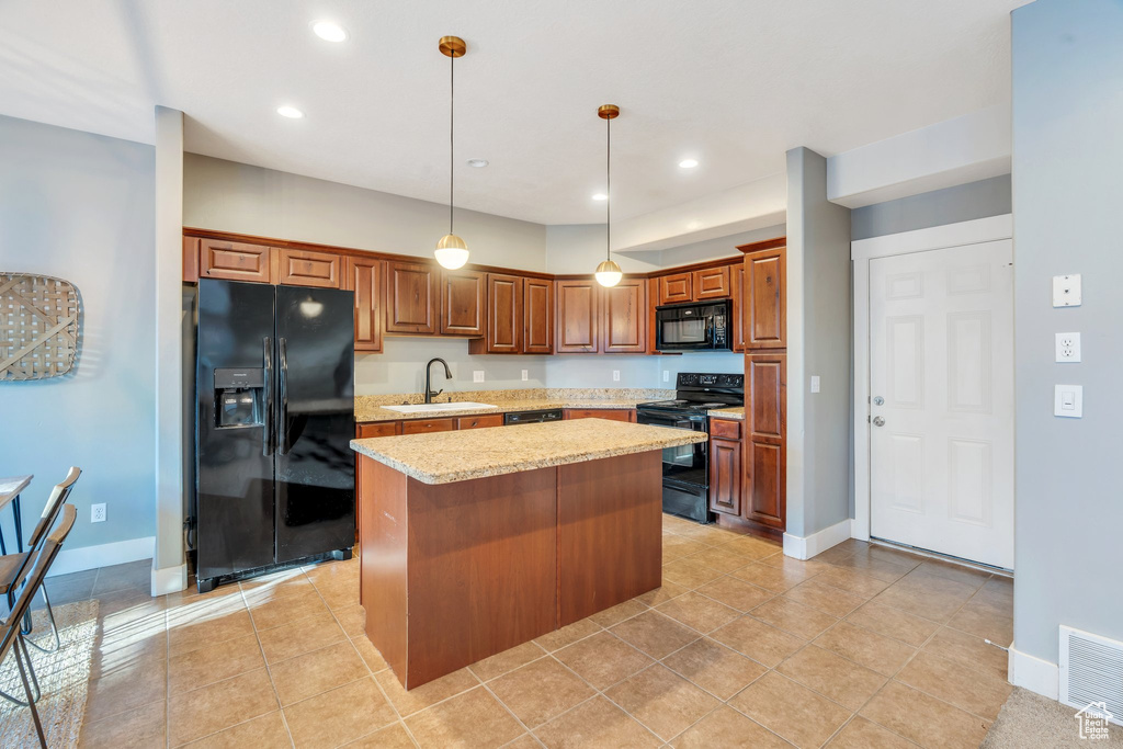 Kitchen with black appliances, a kitchen island, recessed lighting, light stone countertops, and hanging light fixtures