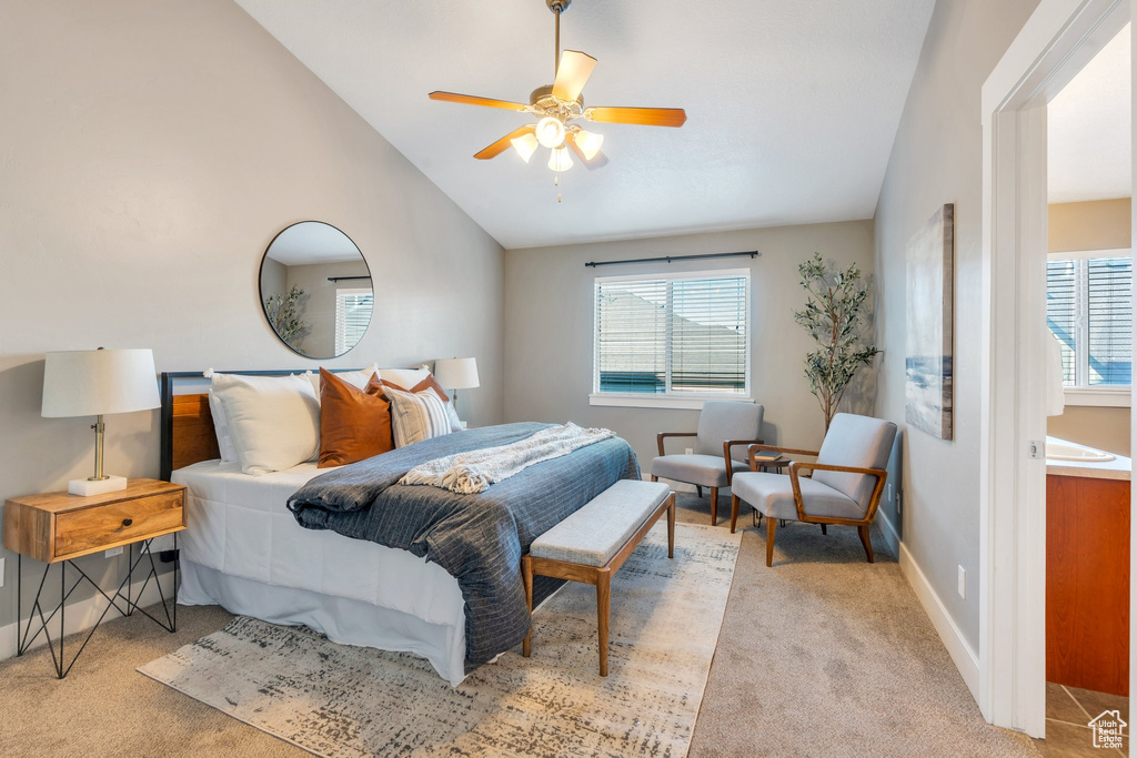 Carpeted bedroom with multiple windows, vaulted ceiling, and ceiling fan