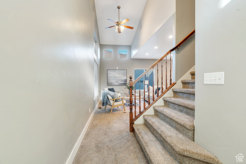 Stairs featuring carpet flooring, a ceiling fan, high vaulted ceiling, and recessed lighting