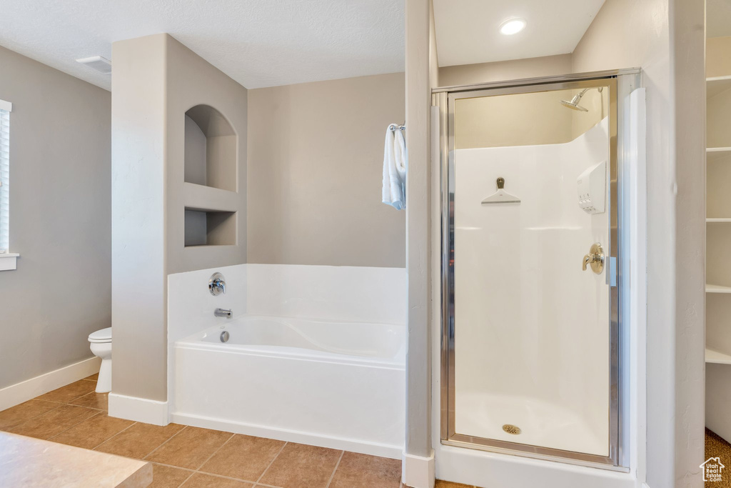 Bathroom featuring a shower stall, a garden tub, and tile patterned floors
