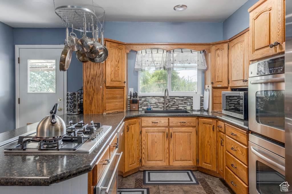 Kitchen with appliances with stainless steel finishes, plenty of natural light, a peninsula, and decorative backsplash