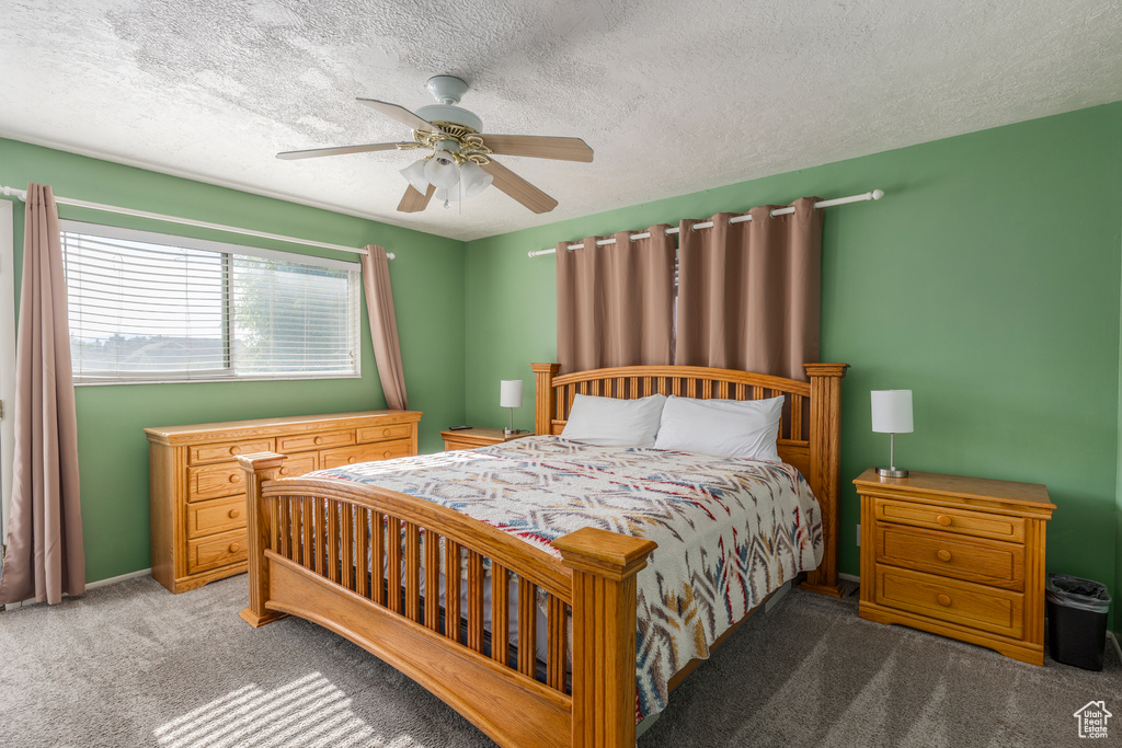 Bedroom with carpet flooring, a textured ceiling, and a ceiling fan