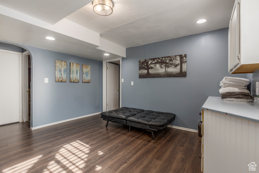 Sitting room featuring arched walkways, dark wood-style flooring, and recessed lighting