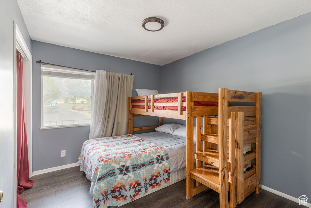 Bedroom with wood finished floors and baseboards