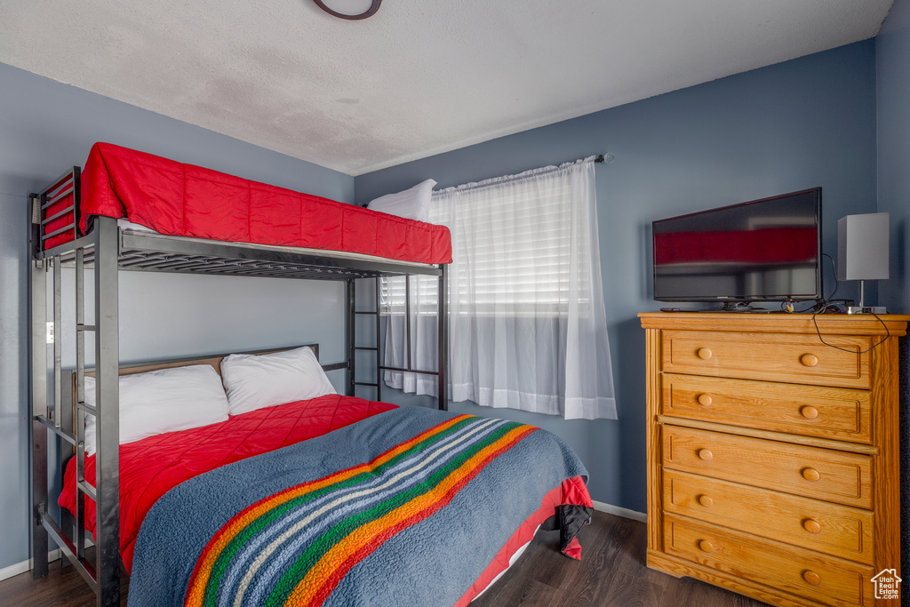 Bedroom featuring dark wood-type flooring and baseboards